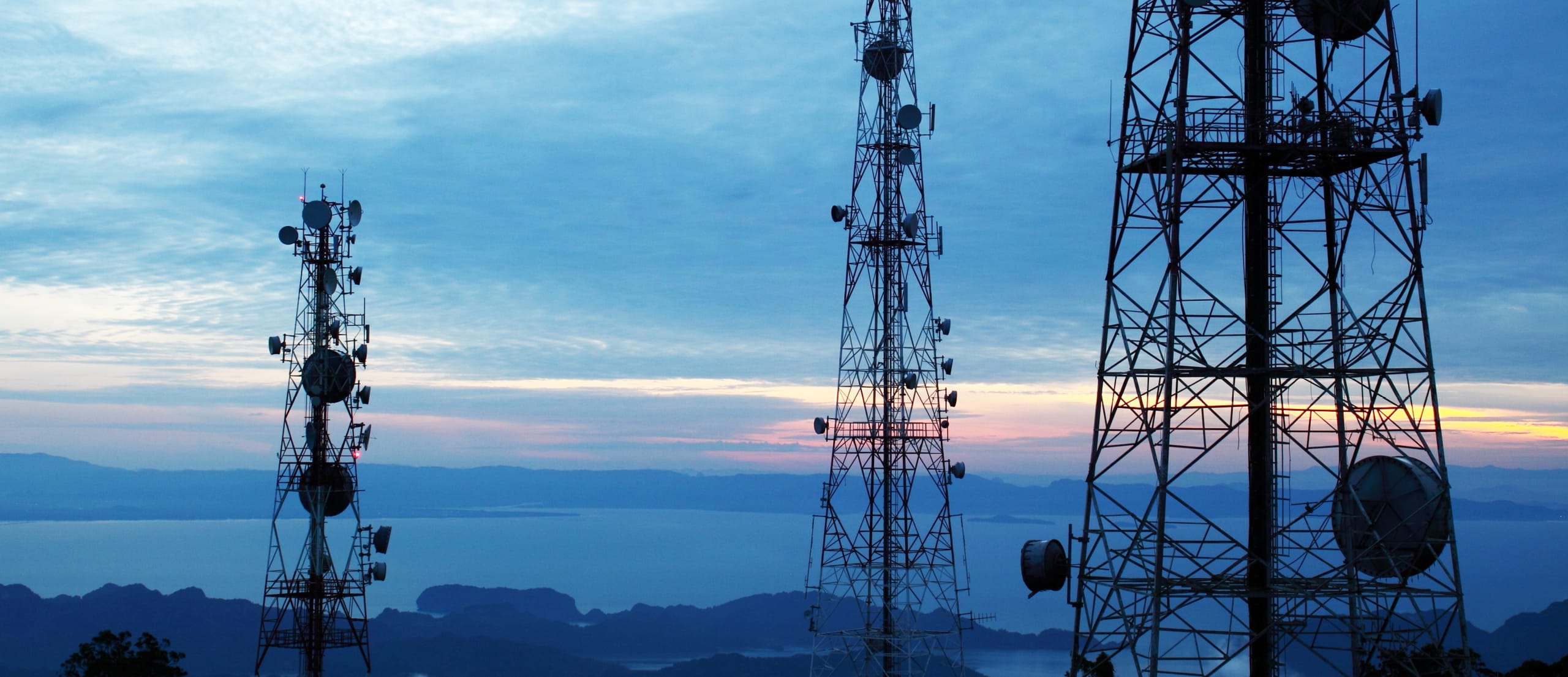 This image shows a skyline at dusk with cellular towers visibile.